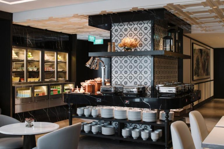 Zona de buffet con chafing dishes y vajilla del restaurante del Grand Park City Hall Singapur
