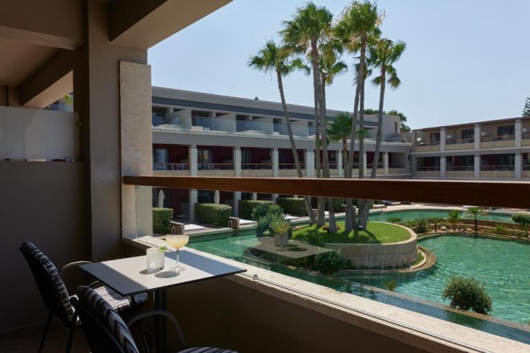 Balcón con vistas a la piscina exterior y jardines del Atlantica Kalliston Resort Adults Only