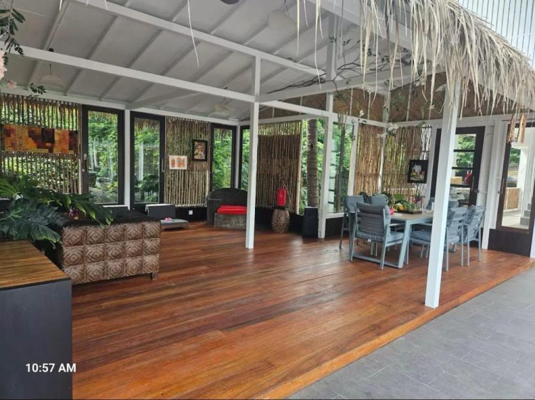 Terraza cubierta con suelo de madera, zona lounge y comedor exterior en 8 Bedroom Monkey Villa