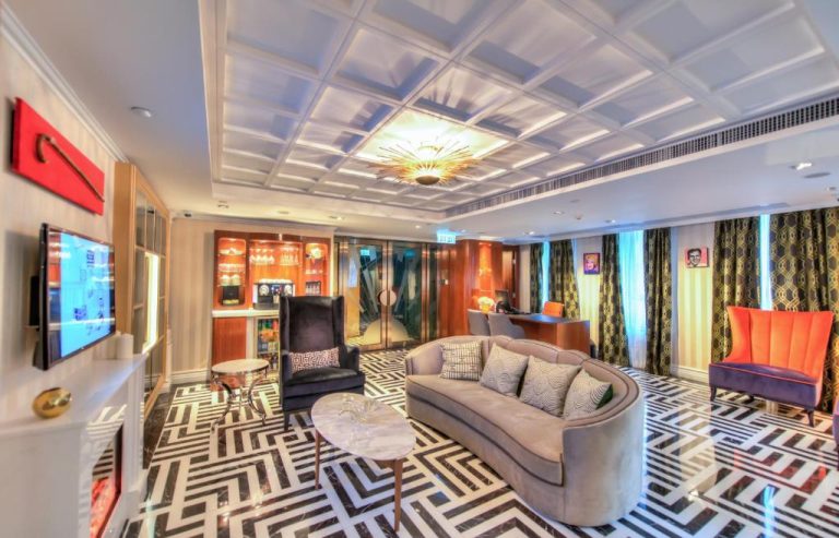 Lujoso salón de suite en Hotel Madera Hollywood con sofá curvo, suelo geométrico y bar privado