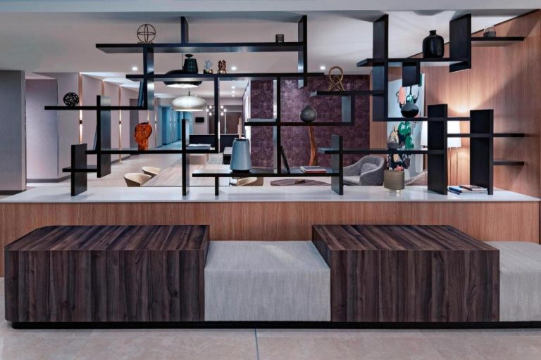 Lobby moderno con estantería decorativa y mobiliario de diseño en AC Hotel by Marriott San José Escazú