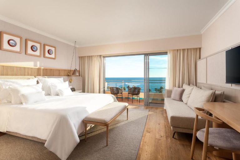 Habitación de lujo con cama doble y balcón con vistas al mar en Grande Real Santa Eulalia Resort