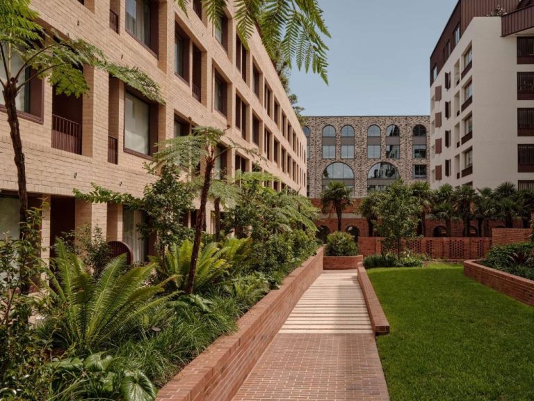 Jardín interior con vegetación tropical y sendero de ladrillo en The EVE Hotel Sydney