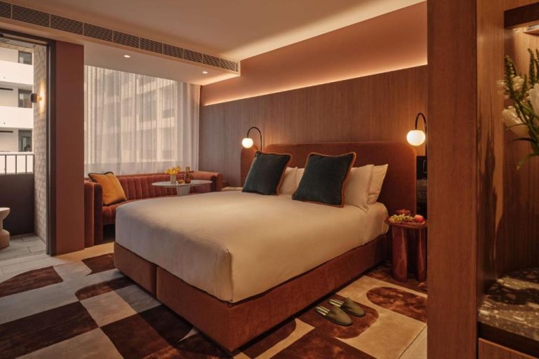 Habitación doble de lujo con cama king size y decoración en tonos tierra del The EVE Hotel Sydney