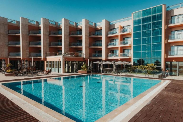 Piscina exterior con tumbonas y sombrillas del Real Marina Hotel & Spa en Portugal