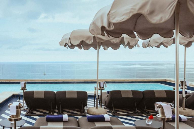 Piscina infinita con tumbonas y sombrillas de lujo con vistas al mar en 1926 Le Soleil Hotel & Spa