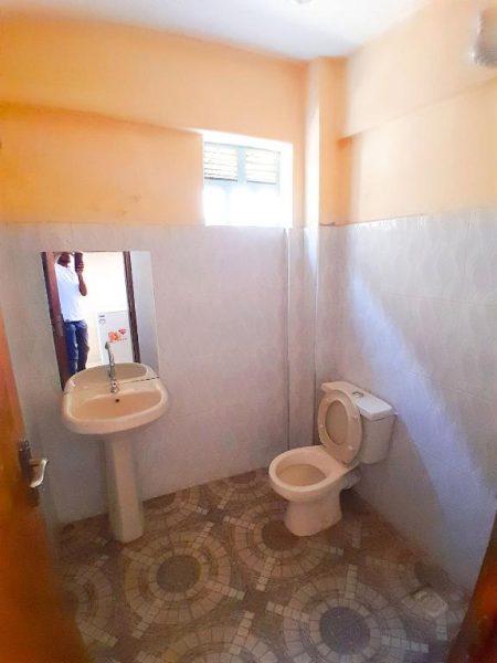 Baño completo con lavabo y inodoro en Villa De Leo, suelo decorativo y ventana con luz natural