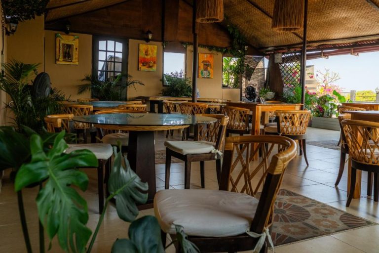 Restaurante terraza con mesas de madera y plantas tropicales en Hotel Marie Real Cartagena