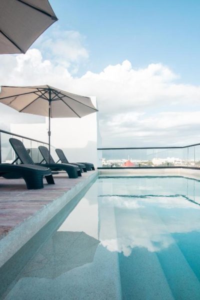 Piscina en azotea con tumbonas y sombrillas del Hotel B10 Distinctive Hotel con vistas a la ciudad