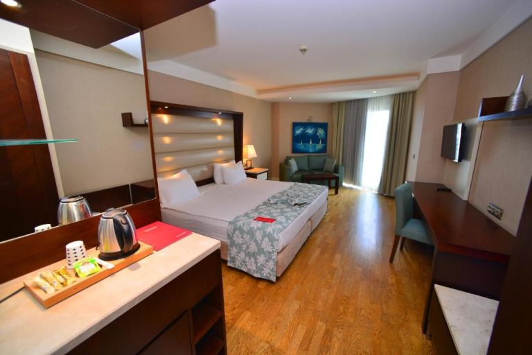 Habitación doble superior con cama king size y zona de estar en Ramada Plaza Antalya