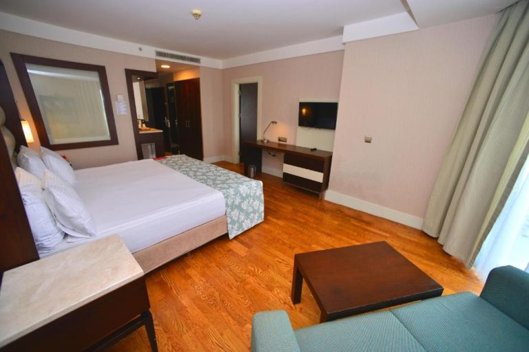 Habitación doble superior con cama king size y salón en el Ramada Plaza Antalya