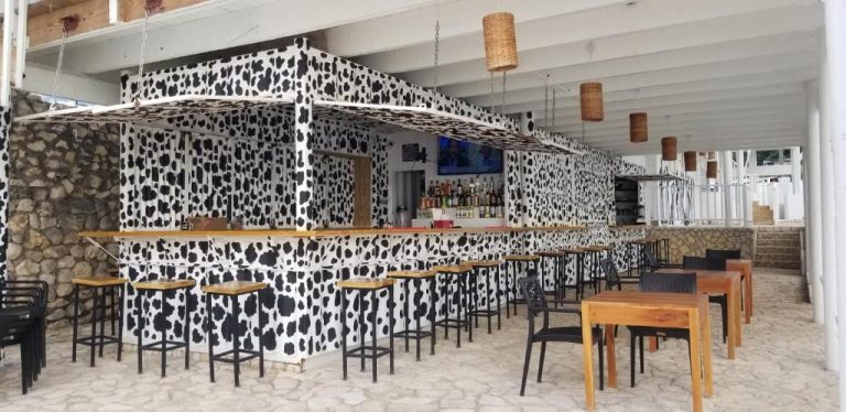 Bar temático con decoración de manchas de vaca y taburetes en el Begona Cliff Hotel
