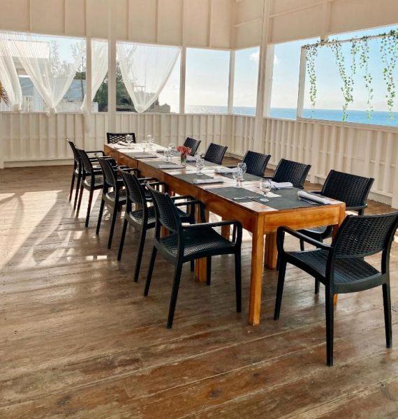 Salón comedor privado con mesa larga y vistas al mar en el Begoña Cliff Hotel