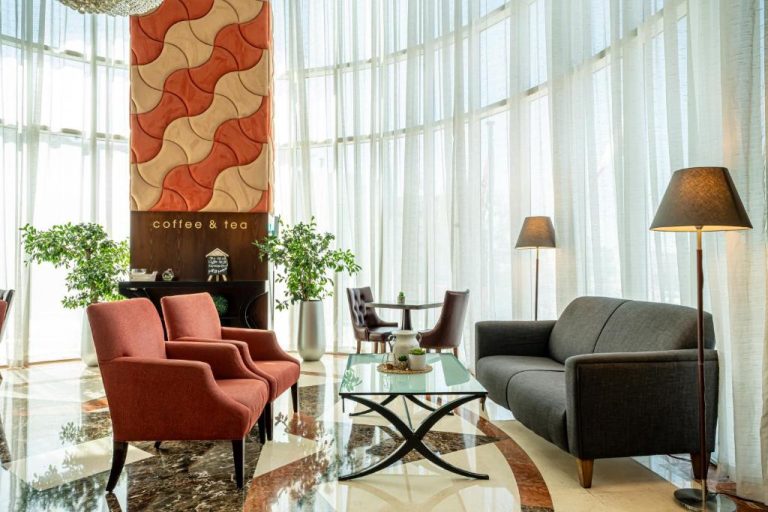 Zona lounge con sofás y cafetería del Kingsgate Hotel Doha by Millennium Hotels en Qatar