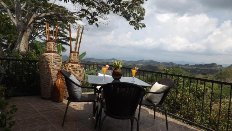 Terraza con mesa y cócteles del Hotel Villas de la Colina con vistas panorámicas a las montañas