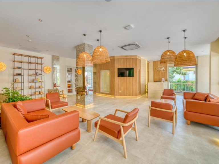 Amplio lobby del Park Hotel con sofás de cuero naranja, sillas de madera y lámparas de mimbre