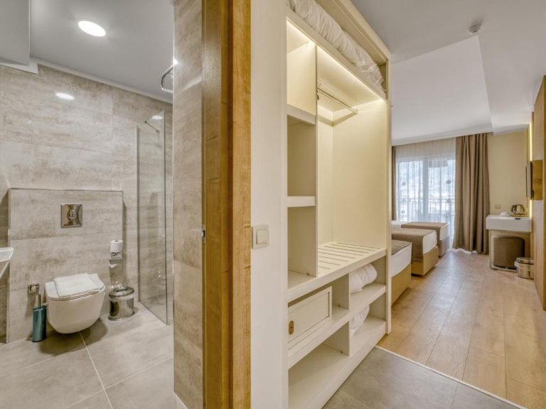Habitación del Park Hotel con baño moderno, ducha, armario empotrado y zona de descanso