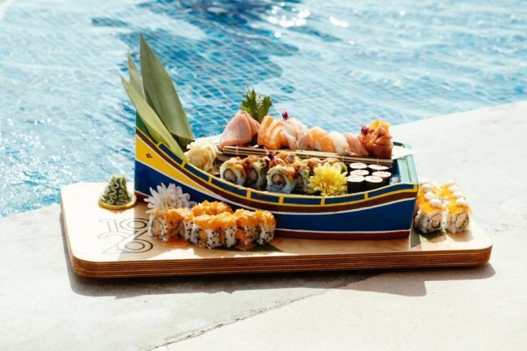 Bandeja de sushi y sashimi en barco decorativo junto a la piscina del 1926 Les Bains Private Spa Suites
