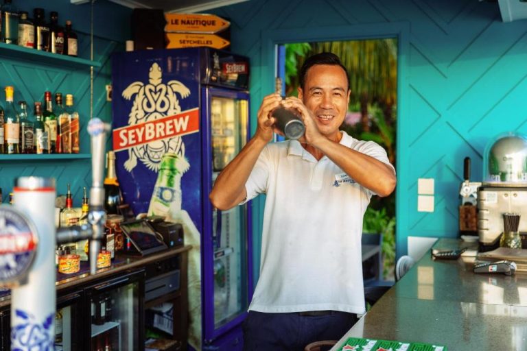 Bartender preparando cócteles en el bar tropical del Le Nautique Waterfront Hotel La Digue, Seychelles