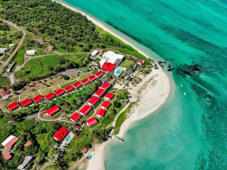 Vista aérea de las villas con tejados rojos del Hotel C Rodrigues Mourouk frente a la playa de aguas turquesas