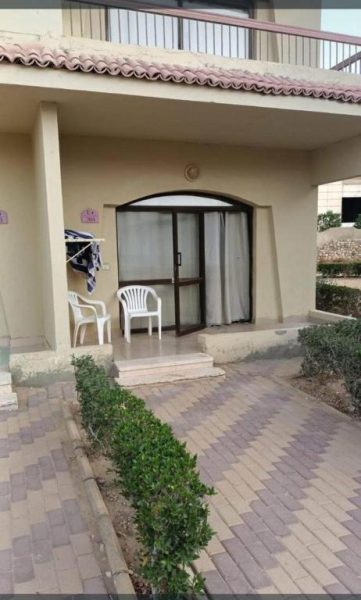 Entrada de bungalow con terraza y sillas blancas en Regina Resort Ain Sokhna, Egipto