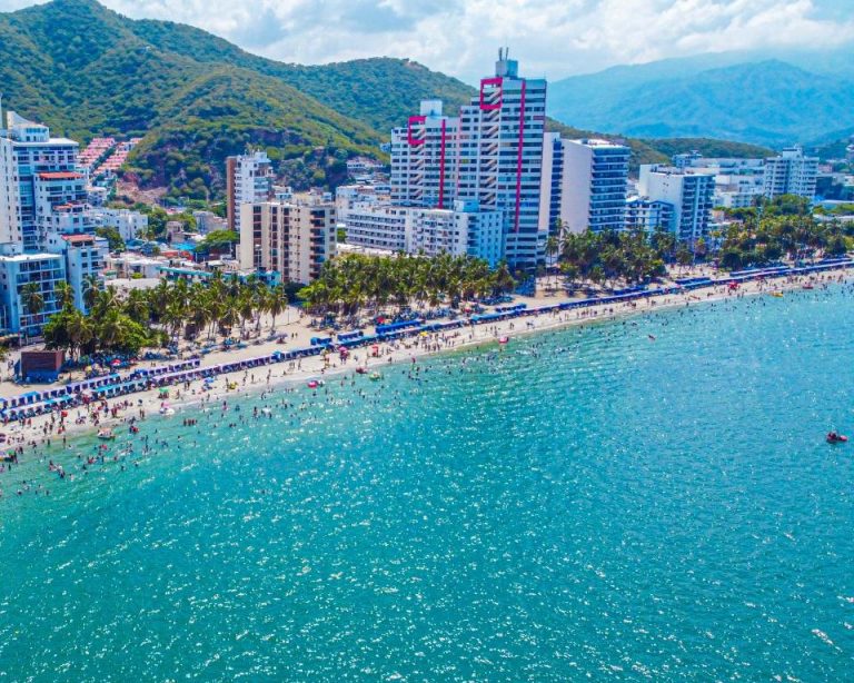 Vista aérea del Azure Apartahotel frente a la playa de Santa Marta con mar turquesa y montañas