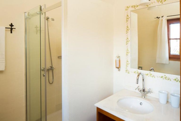 Baño moderno con ducha de mampara de cristal y lavabo del Hotel Atrio