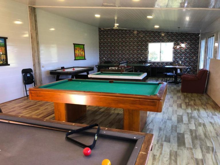 Sala de juegos con mesas de billar, air hockey y futbolín en Complejo La Posta del Hum
