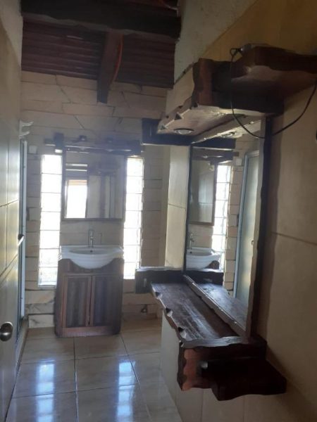 Baño rústico con lavabo y espejo de madera en el Complejo La Posta del Hum