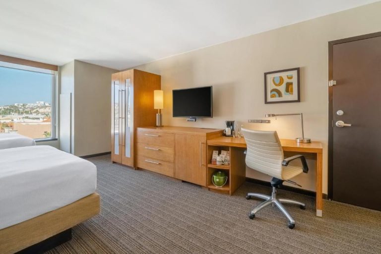 Habitación con escritorio de trabajo, televisión y vistas panorámicas en Hyatt Place Los Cabos