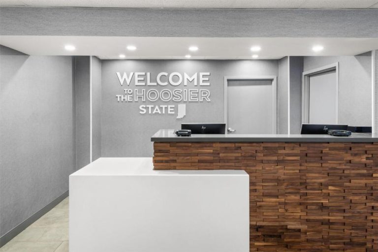 Recepción moderna del Hampton Inn Indianapolis Castleton con cartel bienvenida al estado Hoosier