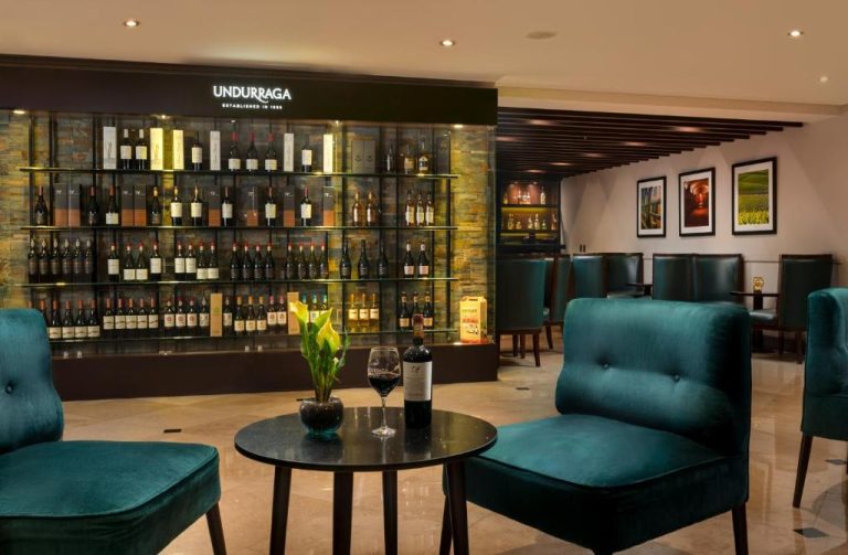 Bar de vinos Undurraga con amplia selección de botellas y sillones de terciopelo en Four Points by Sheraton Santiago