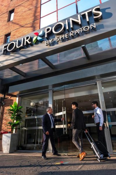 Entrada principal del Four Points by Sheraton Santiago con huéspedes y maletero dando la bienvenida