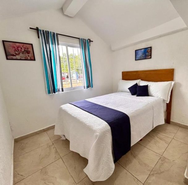 Habitación doble con cama matrimonial y decoración en azul marino en Íkaro Suites Cancún