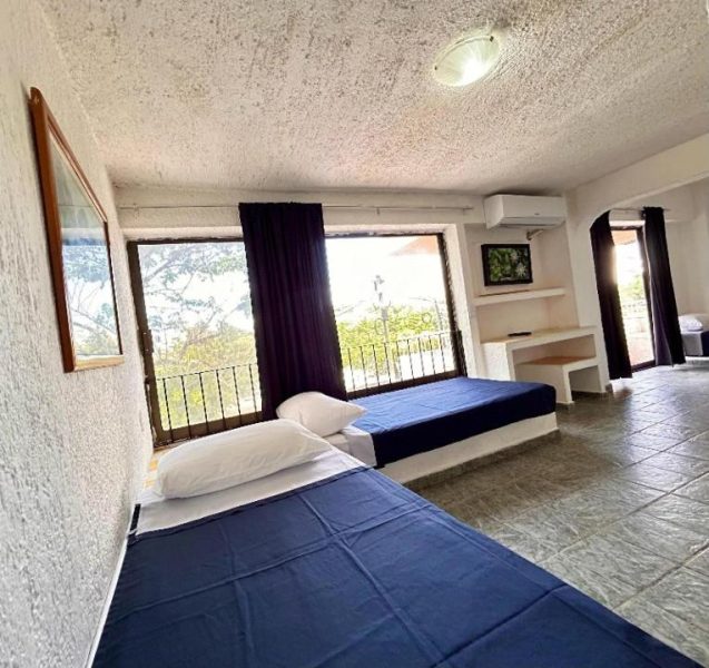 Habitación doble con dos camas y balcón con vista exterior en Íkaro Suites Cancún