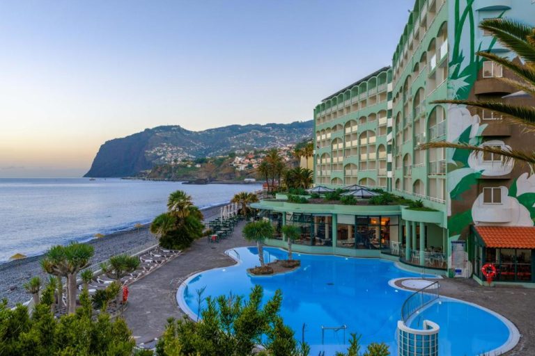 Piscina exterior con vistas al mar y playa del Pestana Ocean Bay Resort en Madeira
