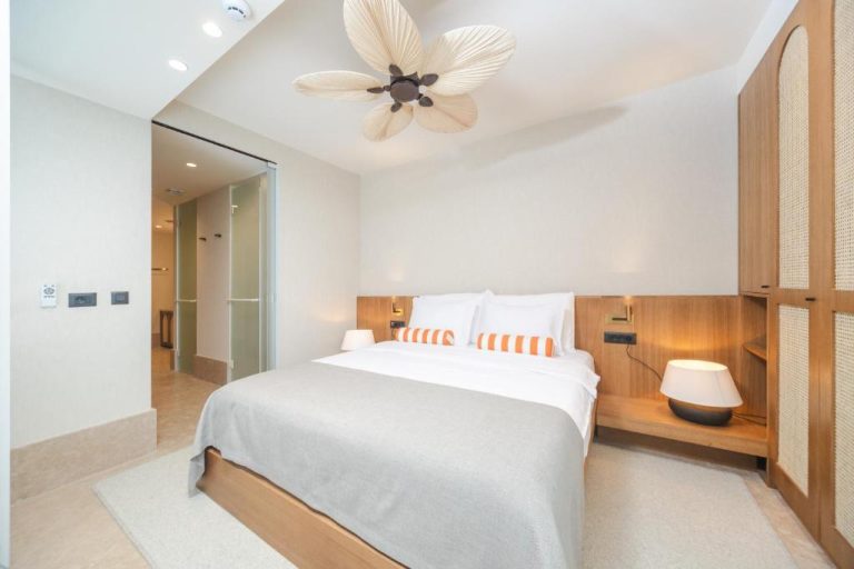 Habitación doble con cama matrimonial y decoración tropical en Infinity Hotel & More
