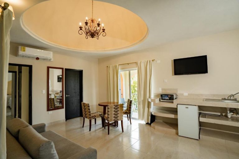 Suite del Gran Sahara con salón, cocina americana, TV y chandelier elegante en el techo