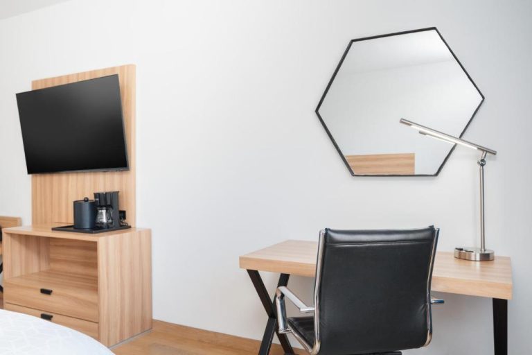 Escritorio de trabajo con silla ejecutiva y espejo hexagonal en Holiday Inn Express Tegucigalpa