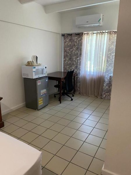 Habitación con minibar, microondas, escritorio y aire acondicionado en Pineapple Court Hotel