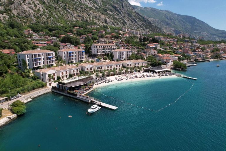 Vista aérea del HUMA Kotor Bay Hotel and Villas con playa privada y bahía de aguas turquesas en Montenegro
