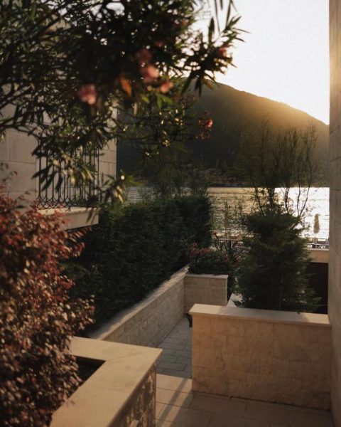 Terraza ajardinada con vistas a la bahía de Kotor al atardecer en HUMA Kotor Bay Hotel and Villas