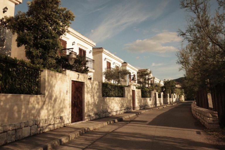 Calle exterior con villas blancas y jardines del HUMA Kotor Bay Hotel and Villas en Montenegro