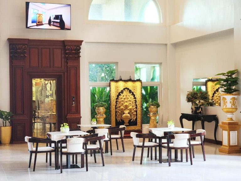 Lobby elegante con decoración dorada y mesas del Lbn Asian Hotel, estilo asiático clásico