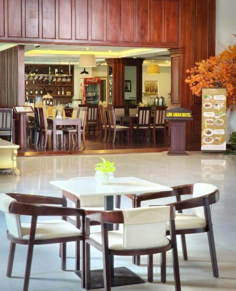 Restaurante y lobby elegante del Lbn Asian Hotel con mesas de madera y decoración asiática