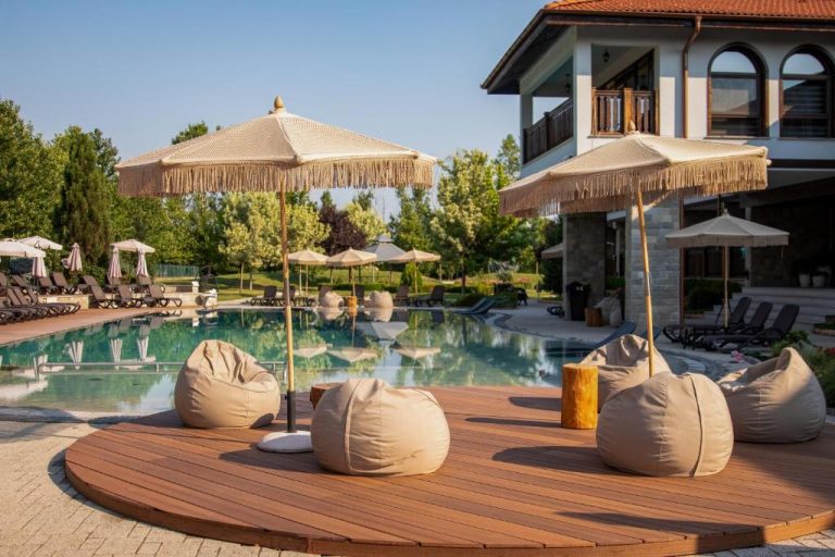 Piscina exterior con puffs y sombrillas tropicales del Boutique Complex Trakiets en Bulgaria