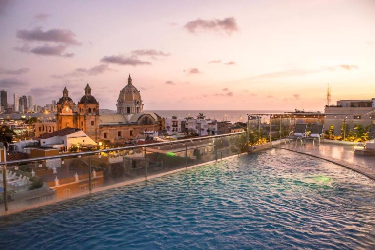 Piscina infinita en la azotea del Movich Hotel Cartagena de Indias con vista a la iglesia y el mar al atardecer