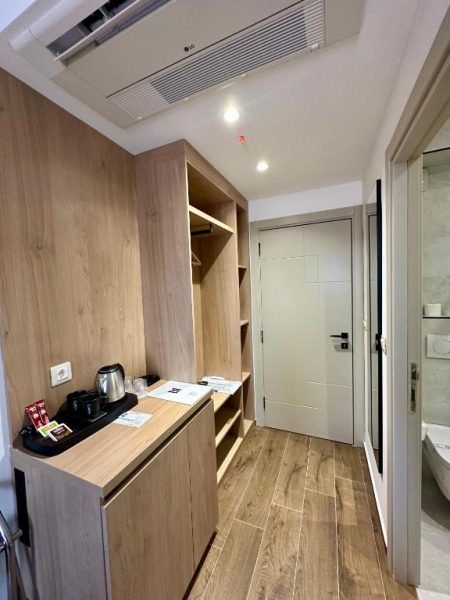 Pasillo con armario empotrado y zona de minibar en madera del Garni Hotel MB Premium
