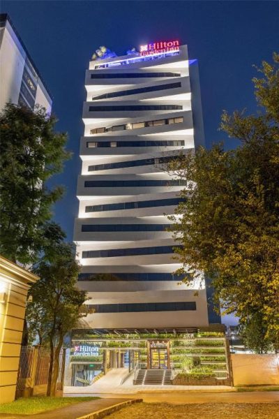 Fachada exterior nocturna del Hilton Garden Inn Asunción Aviadores del Chaco iluminada