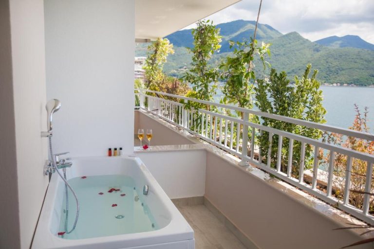 Bañera de hidromasaje en terraza privada con vistas al mar y montañas en Boutique Hotel Blanc & Bleu Blanche